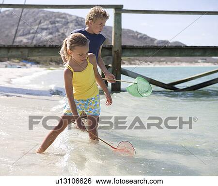 Two children playing in the sea View Large Photo Image Stock Photograph - Two children playing in the sea. Fotosearch