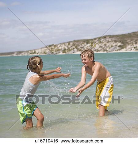 Two children playing in the sea View Large Photo Image Stock Photograph - Two children playing in the sea. Fotosearch