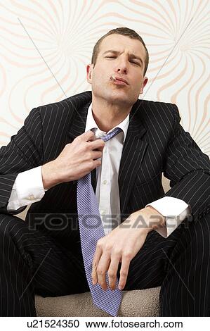 Stock Image - Businessman loosening his tie. Fotosearch