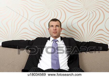 Stock Photo - Businessman sitting on sofa. Fotosearch