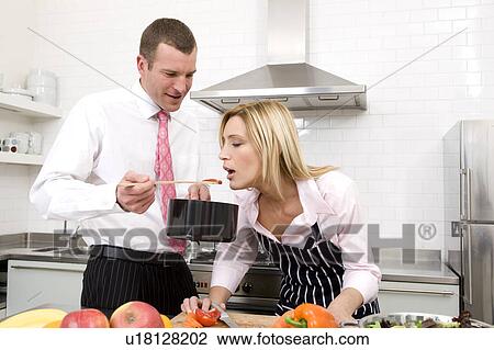 Stock Image - Couple preparing a meal. Fotosearch