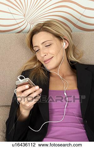 Stock Image - Woman listening to music. Fotosearch