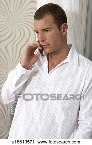 Young man talking on a mobile phone View Large Photo Image Stock Image - Young man talking on a mobile phone. Fotosearch