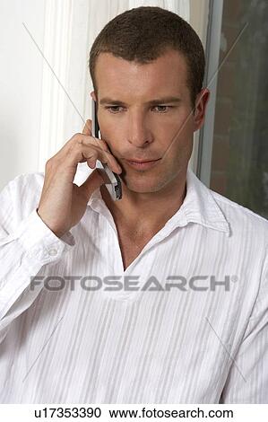 Stock Image - Young man talking on a mobile phone. Fotosearch