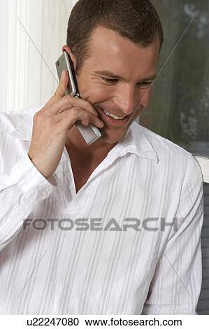 Stock Image - Young man talking on a mobile phone. Fotosearch