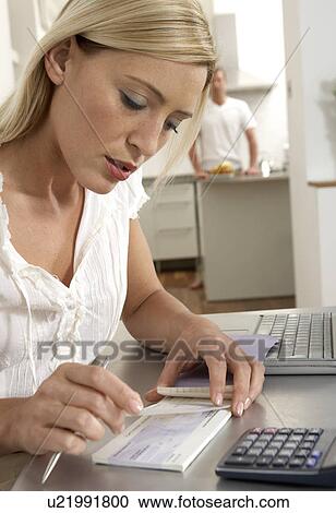 Stock Image - Young woman working from home . Fotosearch