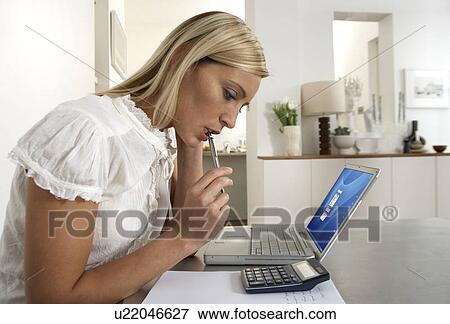 Stock Photo - Young woman working from home. Fotosearch