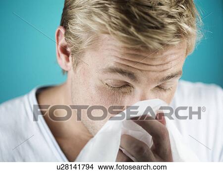 A young man blowing his nose View Large Photo Image Picture - A young man blowing his nose. Fotosearch