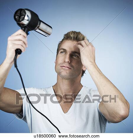 Stock Image - A young man drying his hair. Fotosearch