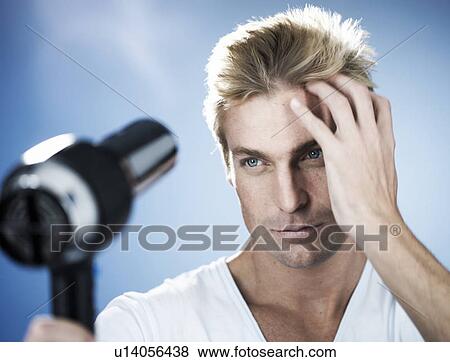 A young man drying his hair View Large Photo Image Stock Photo - A young man drying his hair. Fotosearch