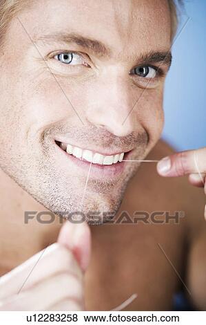 Stock Photo - A young man flossing his teeth. Fotosearch