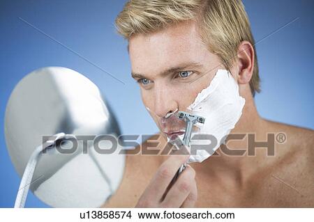 Picture - A young man shaving. Fotosearch