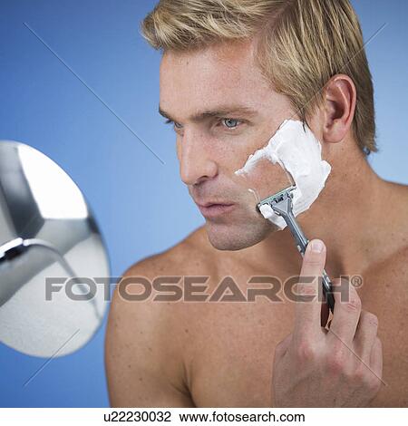 Stock Image - A young man shaving. Fotosearch