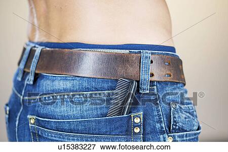 Stock Photo - A young man with a comb in his pocket, close-up. Fotosearch