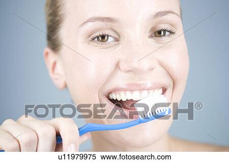 Stock Photography - A young woman brushing her teeth. Fotosearch