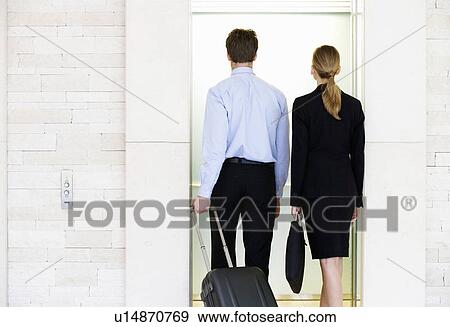 Stock Photo - A businessman and woman with suitcases. Fotosearch