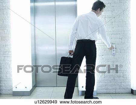 A businessman calling a lift View Large Photo Image Stock Photo - A businessman calling a lift. Fotosearch