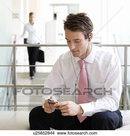 A businessman listening to music View Large Photo Image Picture - A businessman listening to music. Fotosearch
