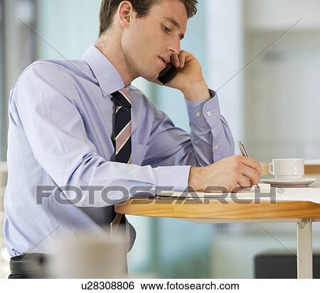 Stock Photograph - A businessman making a diary appointment. Fotosearch