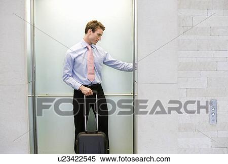 A businessman standing in a lift View Large Photo Image Stock Photography - A businessman standing in a lift. Fotosearch