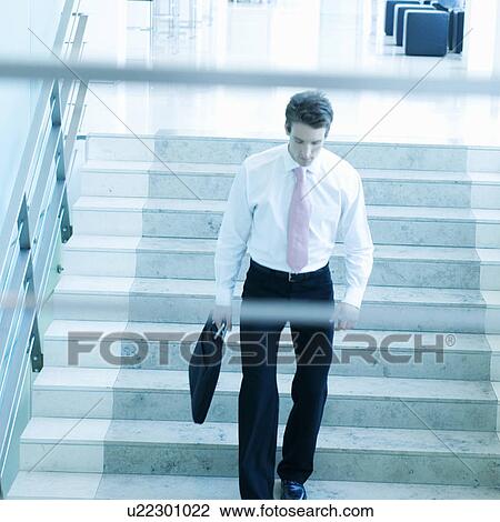 Stock Image - A businessman walking down stairs. Fotosearch
