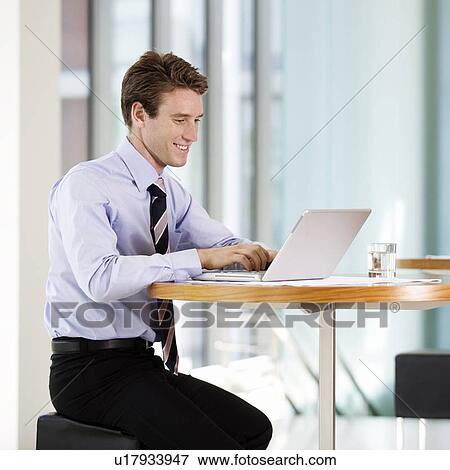 A businessman working on a laptop computer View Large Photo Image Stock Photo - A businessman working on a laptop computer. Fotosearch