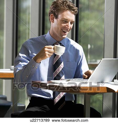 Stock Photo - A businessman working on a laptop computer. Fotosearch