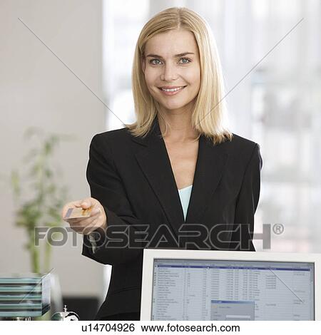 Stock Photograph - A businesswoman paying with a credit card. Fotosearch