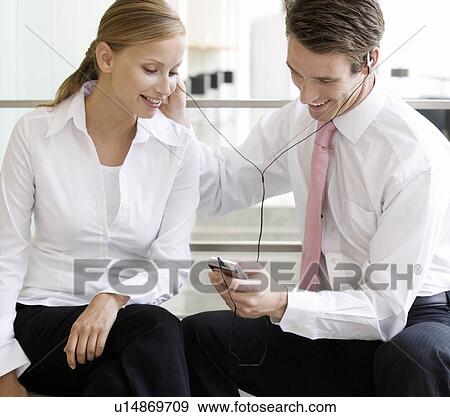 A young working couple listening to music View Large Photo Image Stock Photo - A young working couple listening to music. Fotosearch