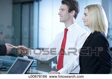 Stock Photograph - Two business colleagues checking in/out. Fotosearch