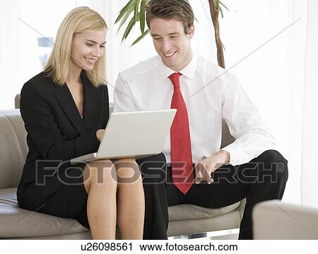 Stock Image - Two business colleagues working on a laptop. Fotosearch
