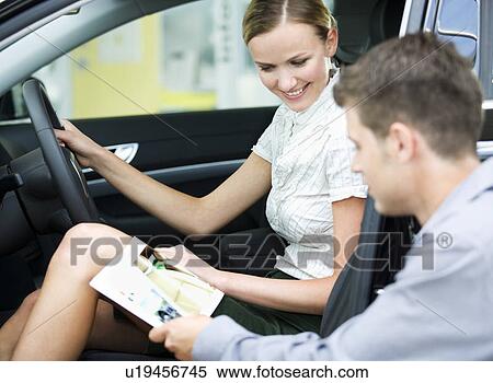 A young couple admiring a new car View Large Photo Image Stock Photography - A young couple admiring a new car. Fotosearch