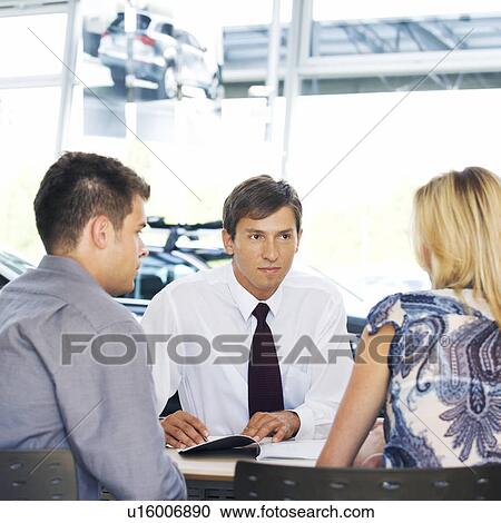 Stock Image - A young couple buying a new car. Fotosearch