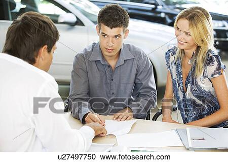 Stock Image - A young couple buying a new car. Fotosearch