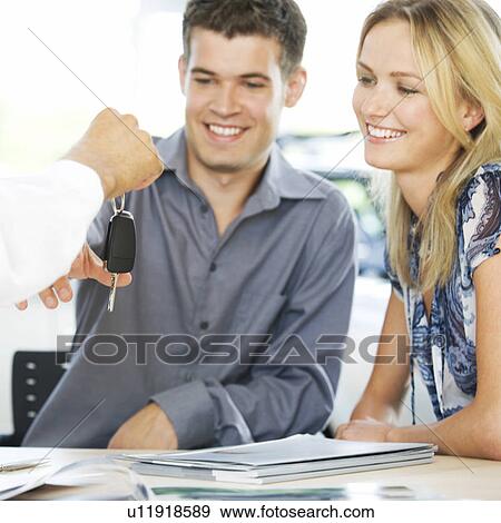 Stock Photo - A young couple buying a new car. Fotosearch