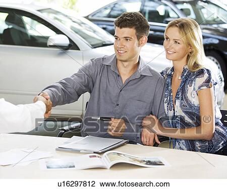 Stock Image - A young couple with keys to a new car. Fotosearch
