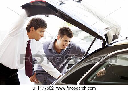 A young man admiring a new car View Large Photo Image Stock Image - A young man admiring a new car. Fotosearch