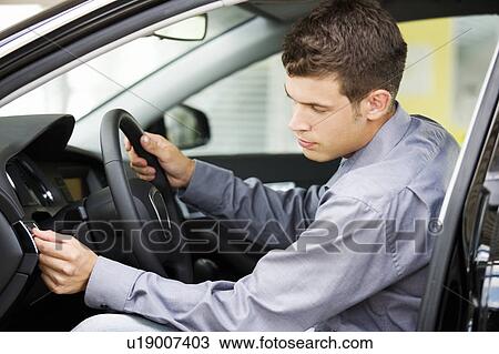 Stock Image - A young man admiring a new car. Fotosearch
