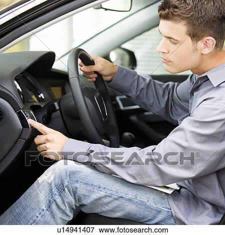 Stock Photo - A young man admiring a new car. Fotosearch
