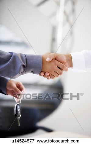 Stock Photo - A young man buying a new car. Fotosearch