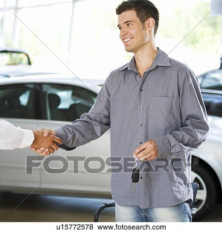 Stock Photo - A young man buying a new car. Fotosearch
