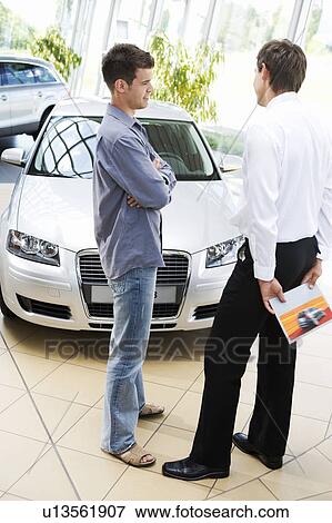 A young man talking to a car salesman View Large Photo Image Stock Photo - A young man talking to a car salesman. Fotosearch
