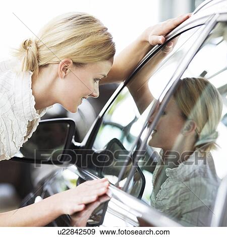 A young woman admiring a new car View Large Photo Image Stock Photo - A young woman admiring a new car. Fotosearch
