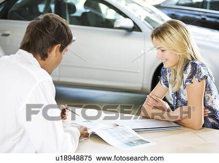 Stock Photography - A young woman buying a new car. Fotosearch