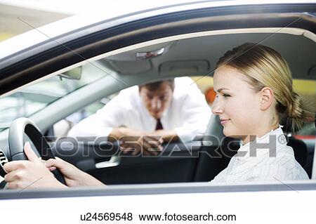 Stock Photo - A young woman sitting in a new car. Fotosearch