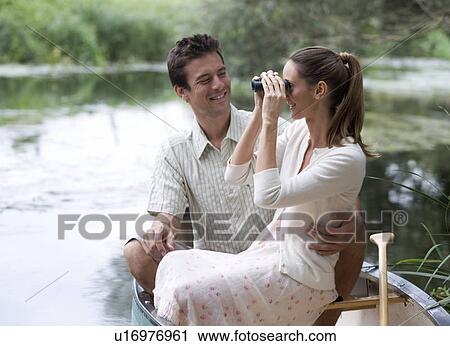 Stock Image - Young couple in a rowing boat. Fotosearch