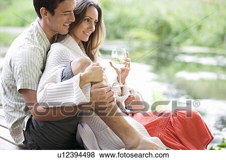 Young couple sitting by a river View Large Photo Image Stock Photo - Young couple sitting by a river. Fotosearch