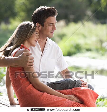 Stock Photo - Young couple sitting in the sun. Fotosearch