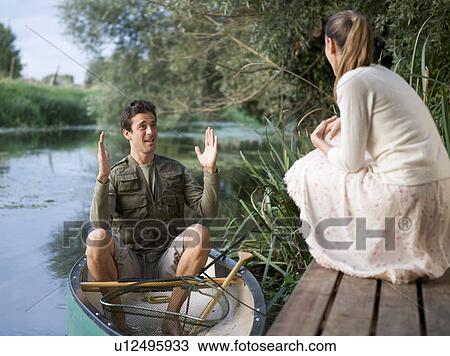 Young man telling tales of the fish that got away View Large Photo Image Stock Image - Young man telling tales of the fish that got away. Fotosearch