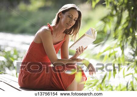 Young woman reading a book View Large Photo Image Picture - Young woman reading a book. Fotosearch
